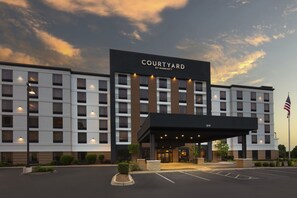 A Courtyard by Marriott hotel with a modern facade, multiple floors, and a covered entrance.