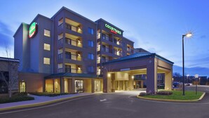 A Courtyard by Marriott hotel with a modern design, multiple floors, and a covered entrance area. - Courtyard Somerset by Marriott (Somerset)