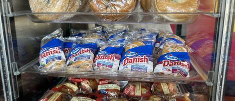 A bakery display with various breads and packaged pastries.