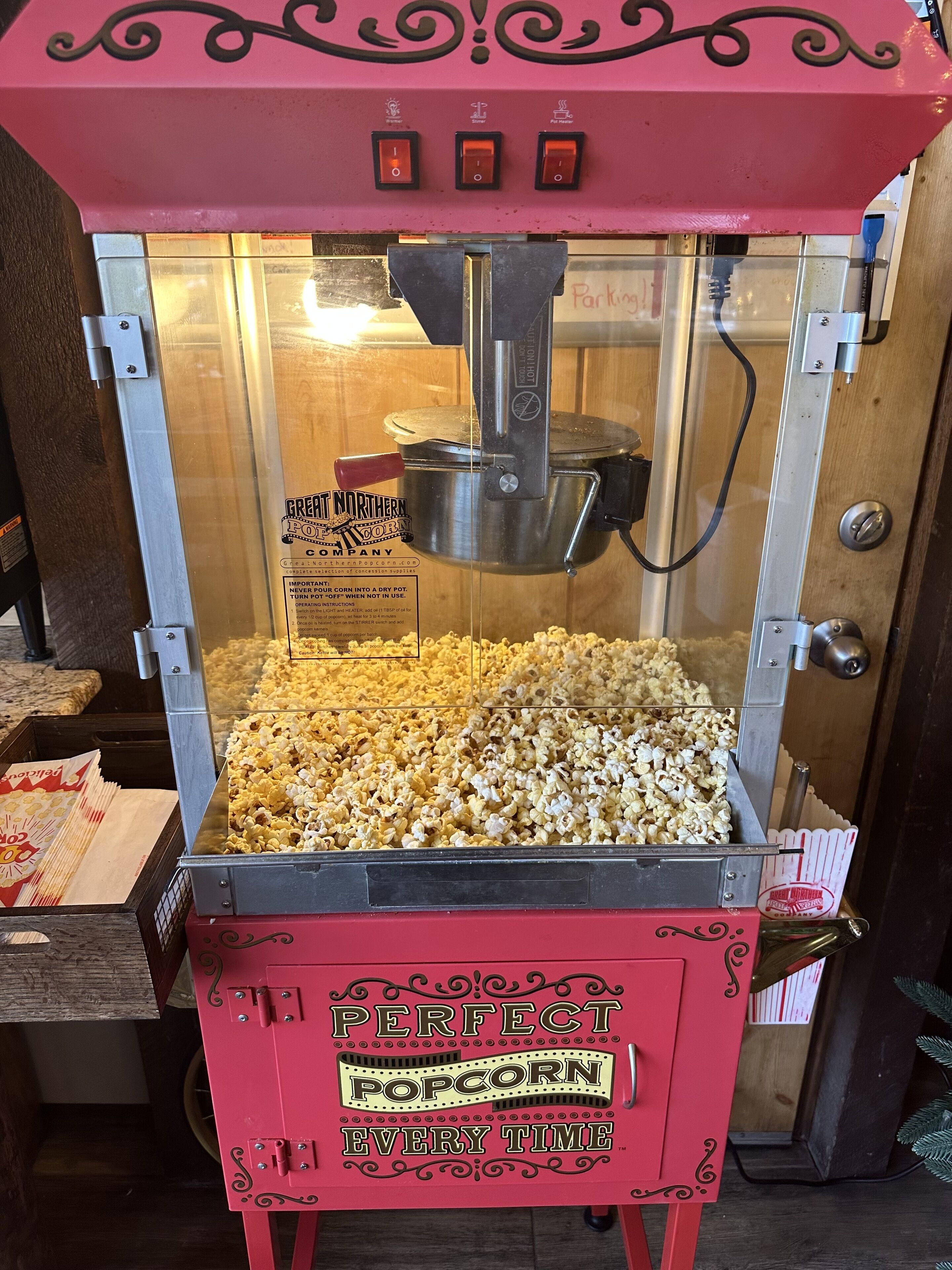Een popcornmachine met een bord waarop staat 