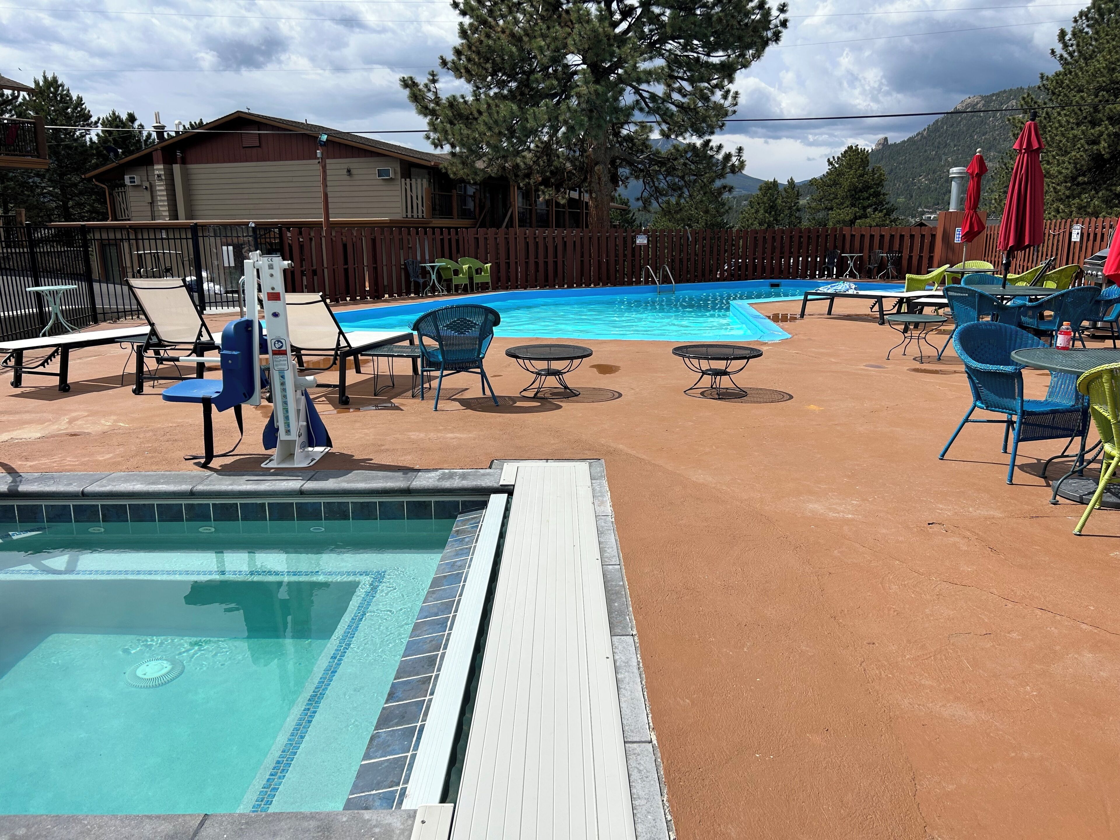 Un espace piscine comprenant des chaises longues, une petite piscine et une terrasse en bois.