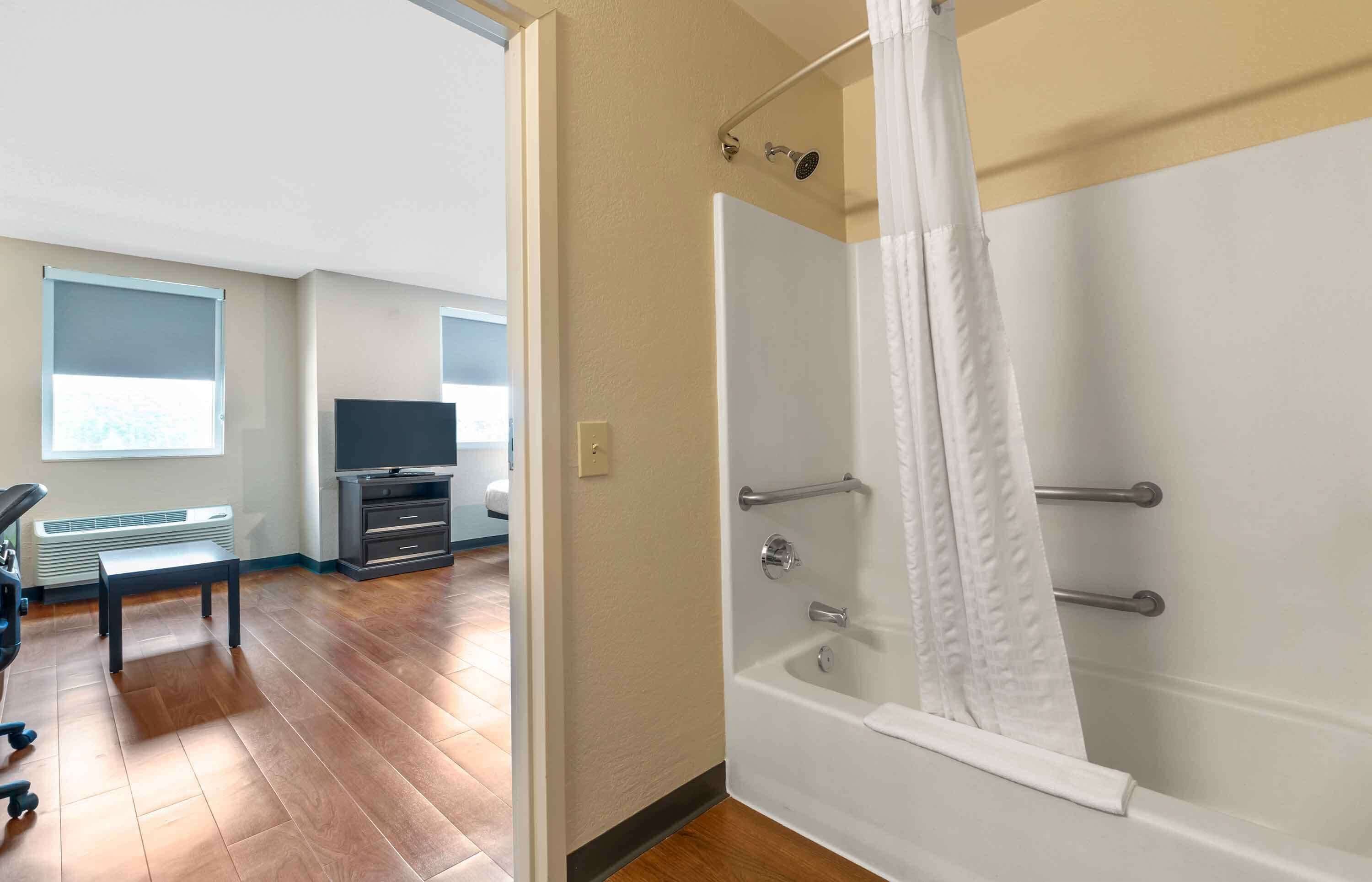 Un baño moderno con ducha a ras de suelo, bañera y retrete.