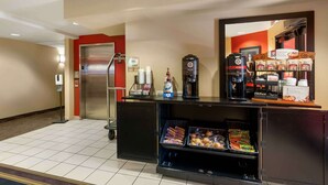 A hotel reception area with a coffee machine, bottled water, and snack dispensers. - Extended Stay America Suites Reno South Meadows (Reno)