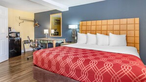 A hotel room with a large bed, a desk with a chair, a microwave, and a mirror. - Econo Lodge Clovis (Clovis)