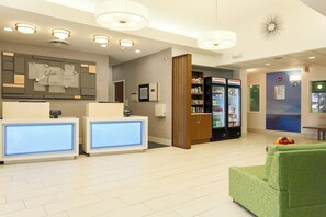 A hotel reception area with a reception desk, a minibar, and a refrigerator.