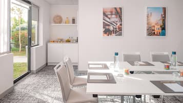 A modern meeting room with a large table, chairs, and artwork on the walls.