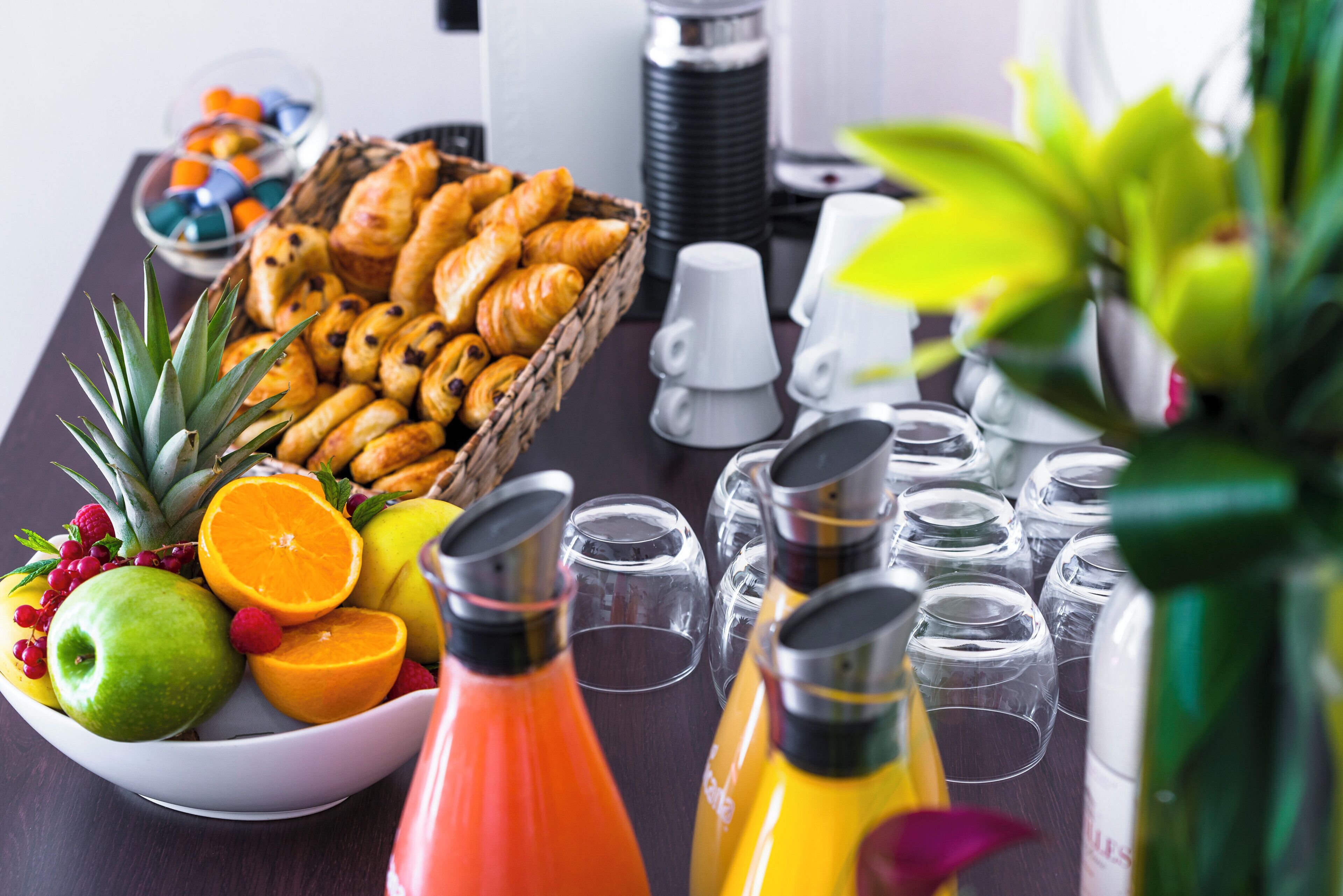 Un bufé de desayuno con bollería, frutas y bebidas.