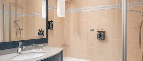 Un baño con bañera, ducha, lavabo y espejo.