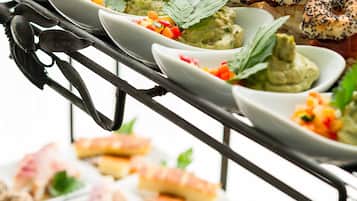 Un buffet proposant une variété de plats, notamment des sauces, des viandes et des accompagnements.