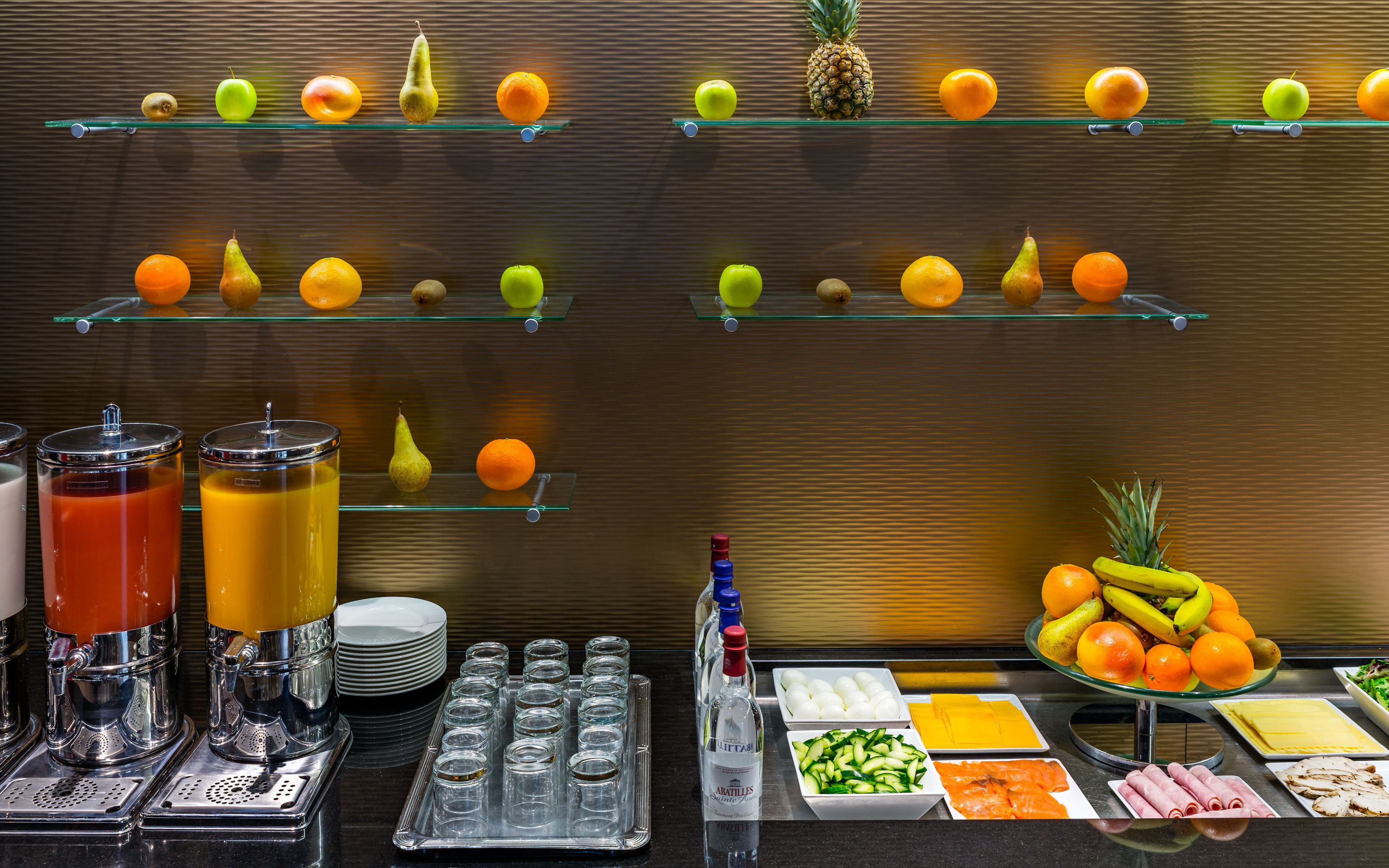 Un buffet proposant une variété de fruits, de boissons et de plats.