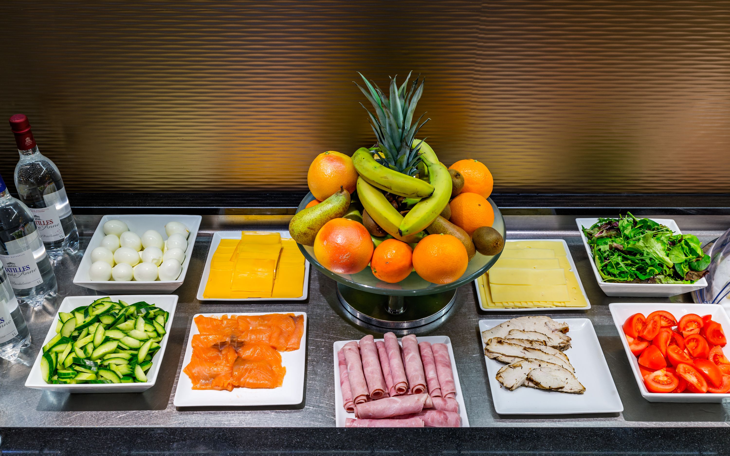 Un bufé con diversos alimentos, incluyendo frutas, verduras, queso y carnes.