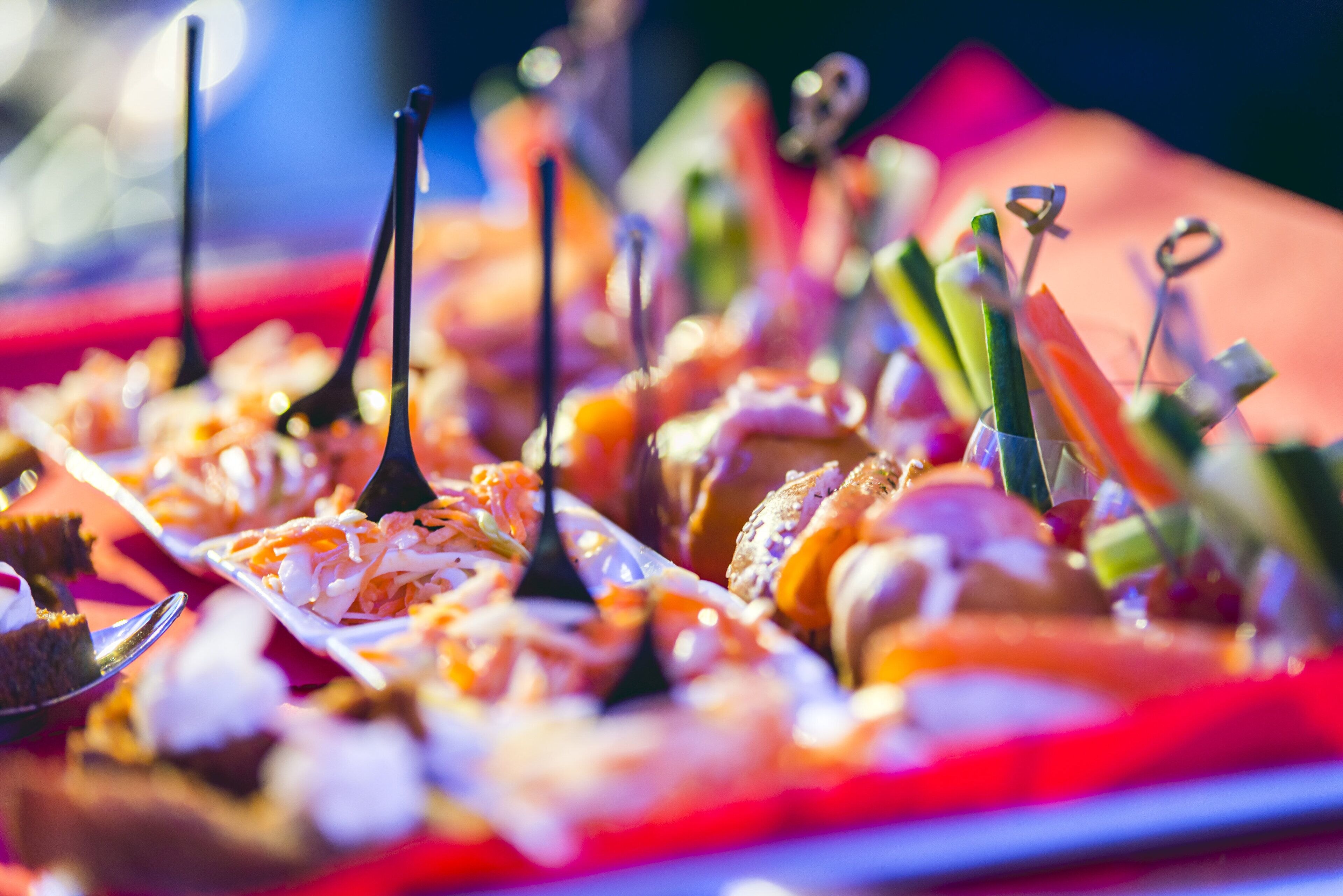 Une variété d’amuse-gueule présentés sur un plateau, avec des brochettes, disposés sur une table.