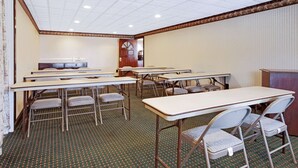 A conference room with multiple tables and chairs, a clock on the wall, and a patterned carpet. - Knights Inn Mount Laurel (Mount Laurel)