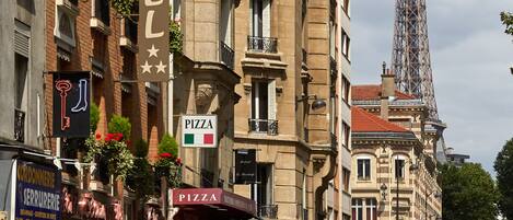 A hotel with a sign indicating it offers pizza.