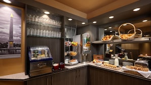 A breakfast buffet with various food items, a coffee machine, and glassware.