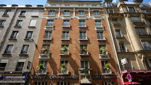 A multi-story hotel with balconies, a sign for a pizza restaurant, and a visible hotel name.