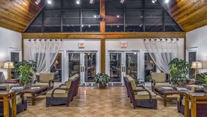 A spacious lobby with a high ceiling, two exits, and comfortable seating areas with tables and chairs. - Hilton Vacation Club Polynesian Isles Kissimmee (Kissimmee)