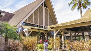 A resort with a thatched-roof pavilion, a large decorative vase, and tropical plants. - Hilton Vacation Club Polynesian Isles Kissimmee (Kissimmee)