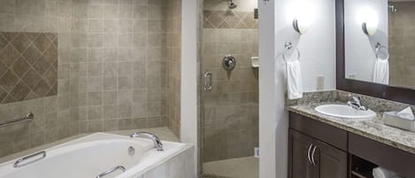 A modern bathroom with a bathtub, shower, and vanity.