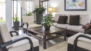 A living room with a sofa, chairs, a coffee table, and potted plants. - Hilton Vacation Club Polynesian Isles Kissimmee (Kissimmee)
