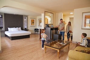 A hotel room with a bed, a desk, a chair, a coffee machine, and a mirror. - The Greenwell Inn (Price)