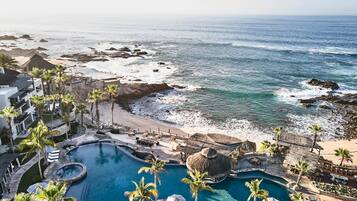 Un resort con una piscina amplia, playa y vistas al océano.