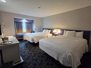 A hotel room with two beds, a desk, and a window with curtains. - Microtel Inn & Suites by Wyndham Hagerstown by I-81 (Hagerstown)