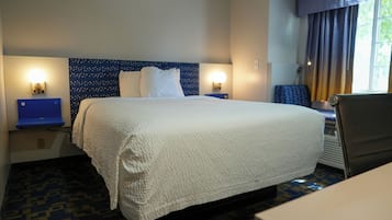 Habitación de hotel con una cama grande, dos lámparas de noche, un escritorio y una silla.
