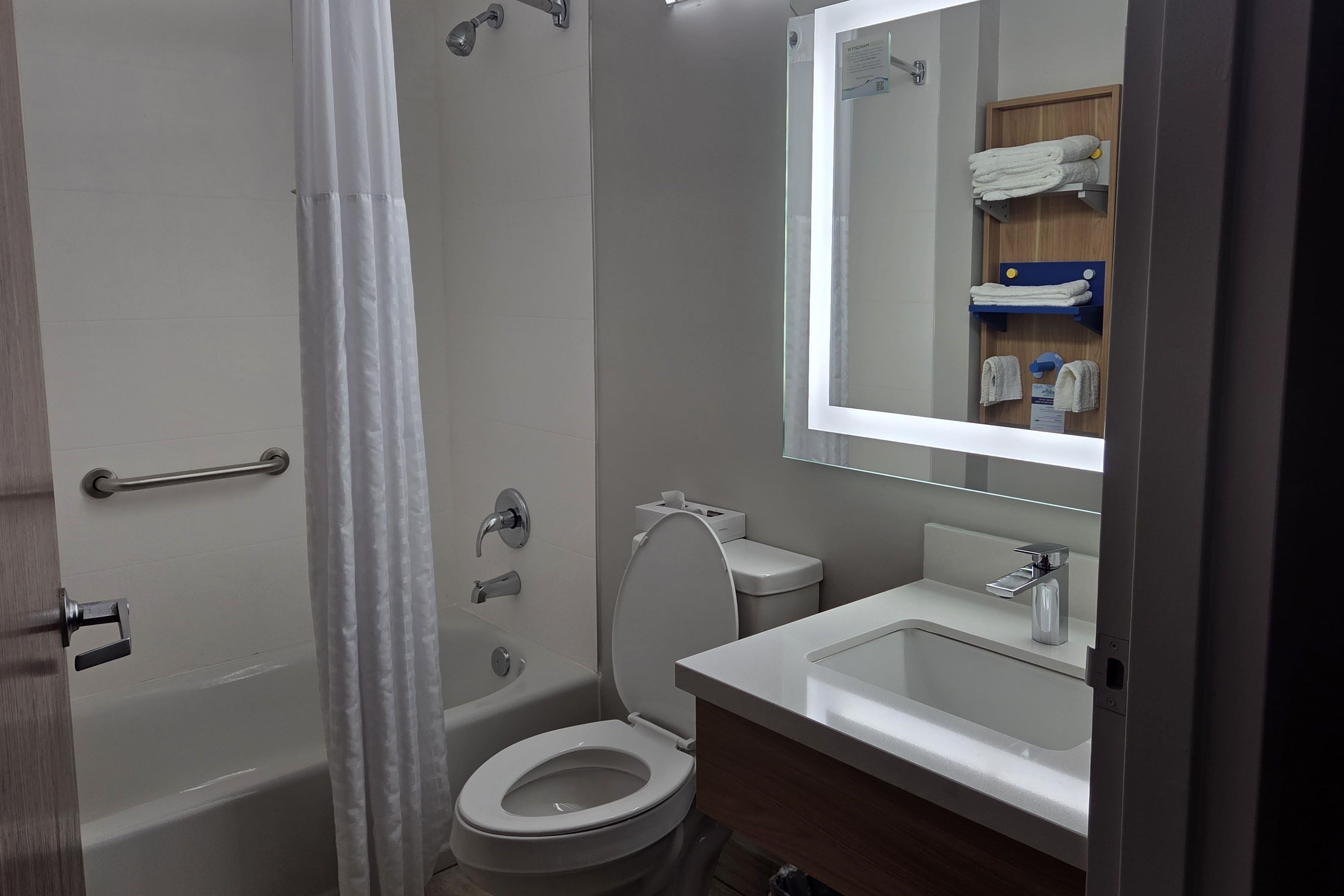 Une salle de bain avec des toilettes, un lavabo et une douche.
