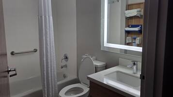 A bathroom with a toilet, sink, and shower.