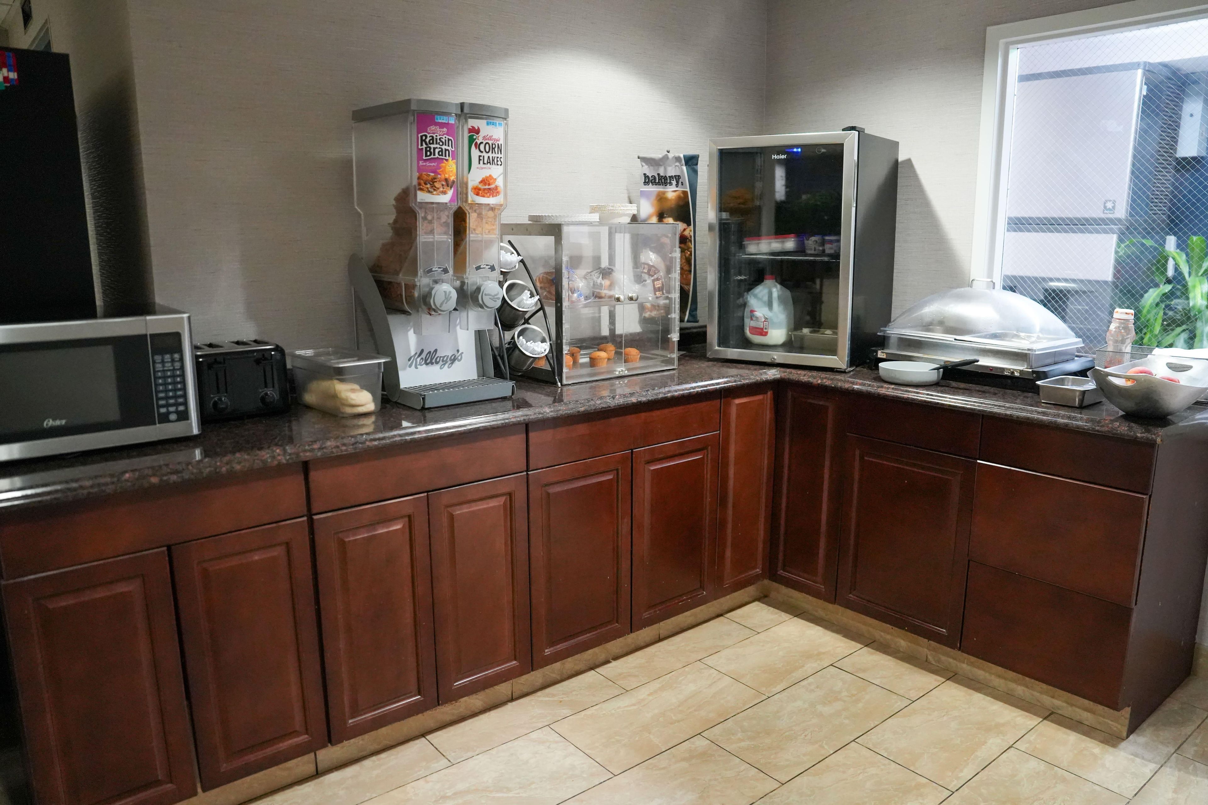 Una cocina equipada con microondas, tostadora, cafetera y refrigerador.