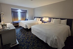 A hotel room with two beds, a desk, a chair, a window with curtains, and a patterned carpet. - Microtel Inn & Suites by Wyndham Hagerstown by I-81 (Hagerstown)