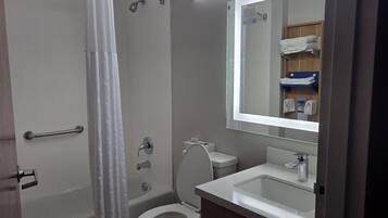 A bathroom with a bathtub, toilet, and sink.