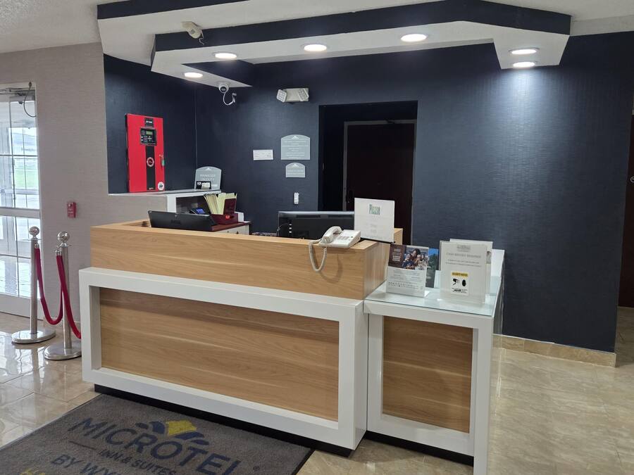 A reception desk with a computer, a phone, and a sign indicating a manager on duty.