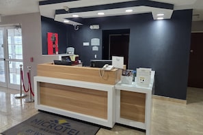 A reception desk with a computer, a phone, and a sign indicating a manager on duty. - Microtel Inn & Suites by Wyndham Hagerstown by I-81 (Hagerstown)