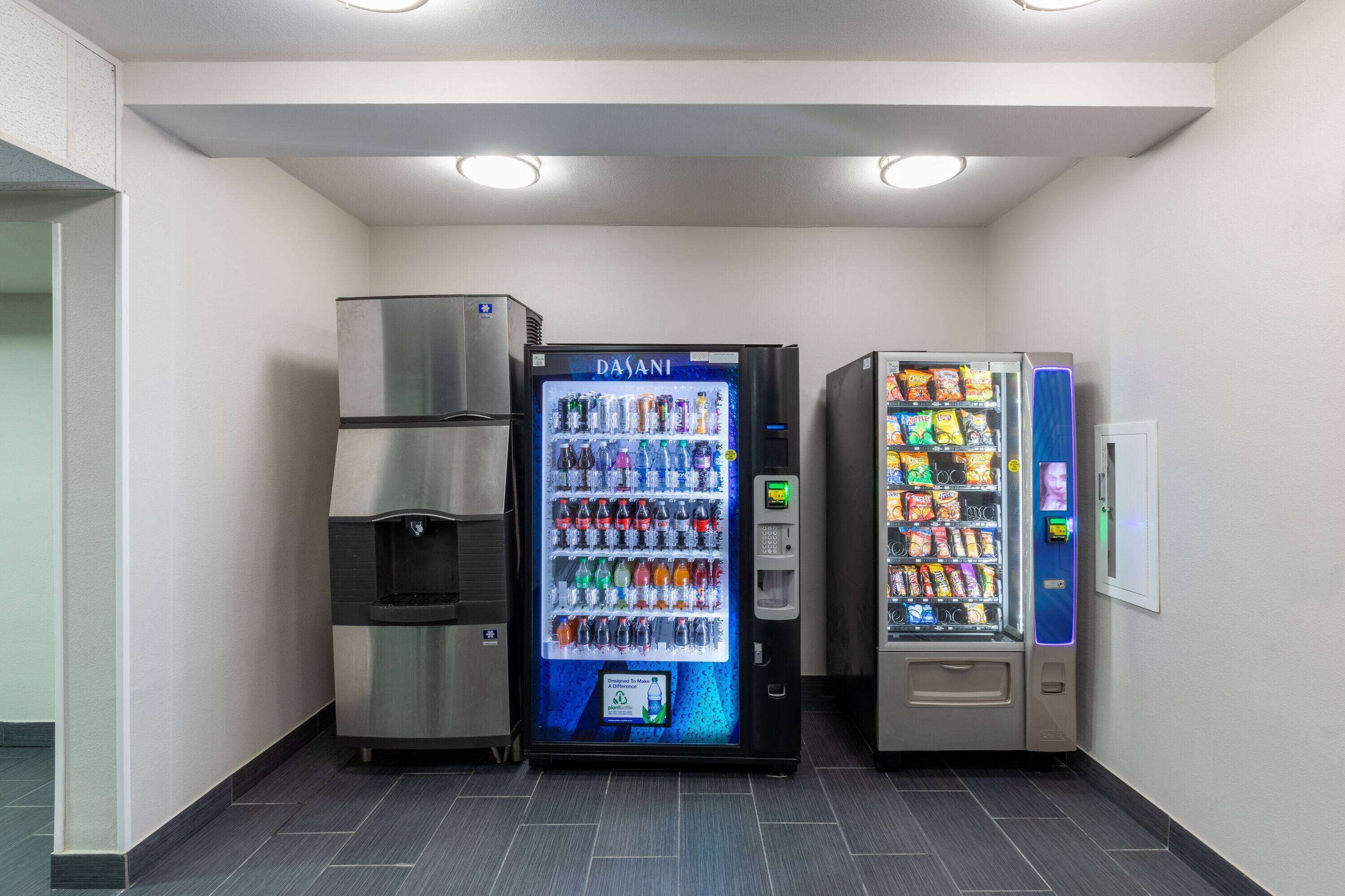 Un área de venta con dispensador de agua, máquina expendedora de bebidas y máquina expendedora de snacks.