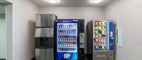 Un área de venta con dispensador de agua, máquina expendedora de bebidas y máquina expendedora de snacks.