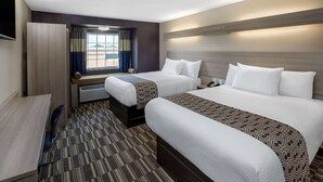 A hotel room with two beds, a desk, and a window with curtains. - Microtel Inn & Suites by Wyndham Bossier City (Bossier City)