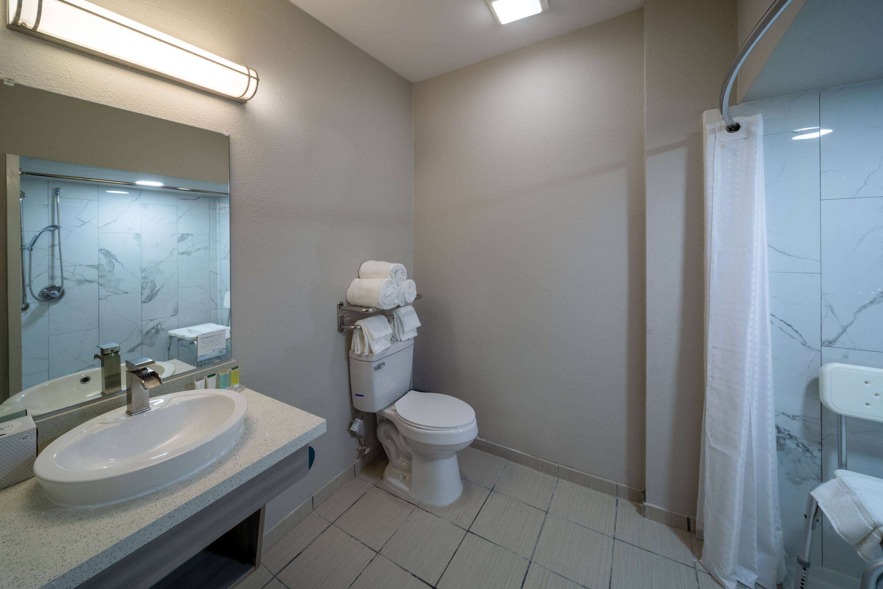 A bathroom with a sink, toilet, and shower.