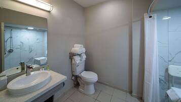 Un baño con lavamanos, inodoro y ducha.
