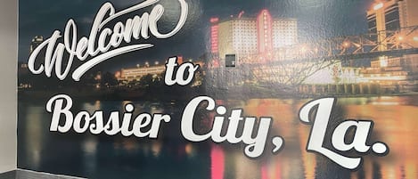 Una pared con un cartel que dice 'Welcome to Bossier City, La'.