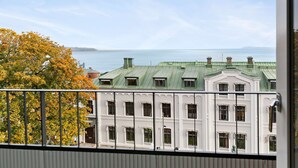 A view of a building with multiple windows and a green roof, overlooking a body of water.