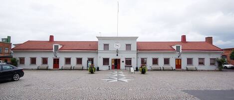 A white building with a red roof, a clock, and a central entrance.