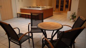 Una cocina con isla central, un jacuzzi y una zona de estar con sillas y una mesa.