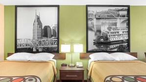 A hotel room with two beds, a nightstand with a lamp, and two framed cityscape pictures on the wall. - Super 8 by Wyndham Nashville West (Nashville)
