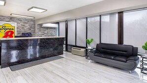 A modern reception area with a marble counter, a black leather sofa, and large windows. - Super 8 by Wyndham Nashville West (Nashville)