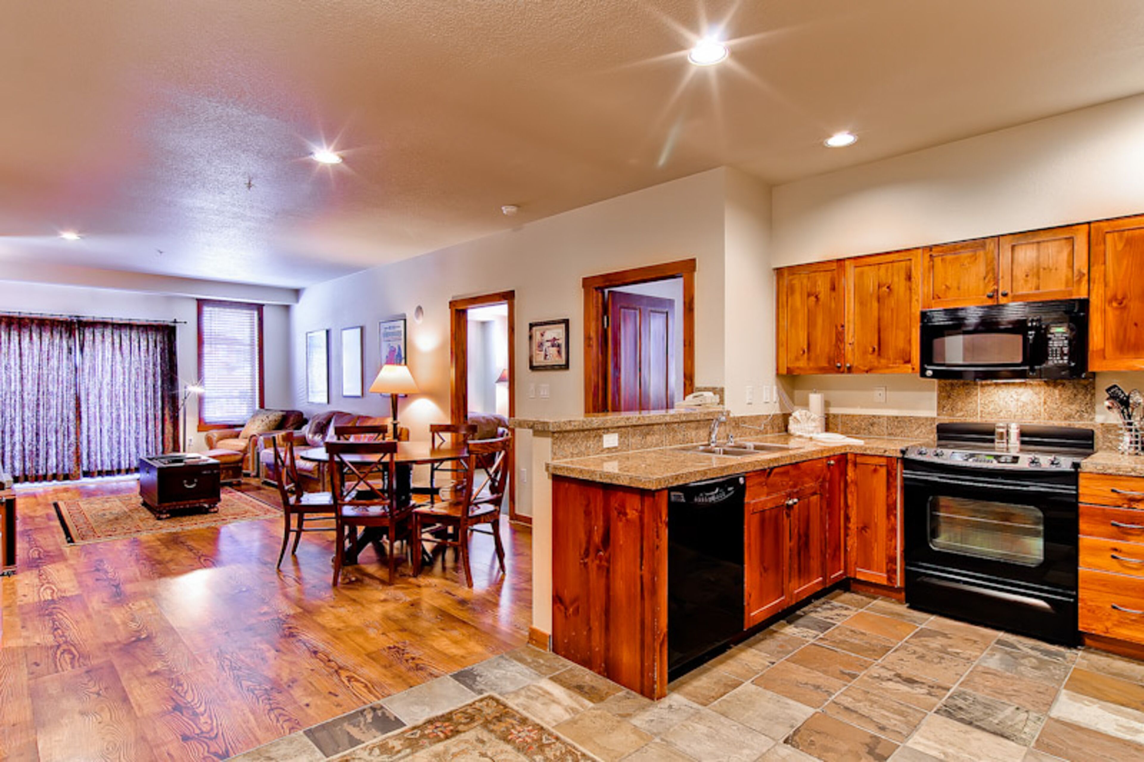 A spacious kitchen with wooden cabinets, a built-in microwave, and an oven.