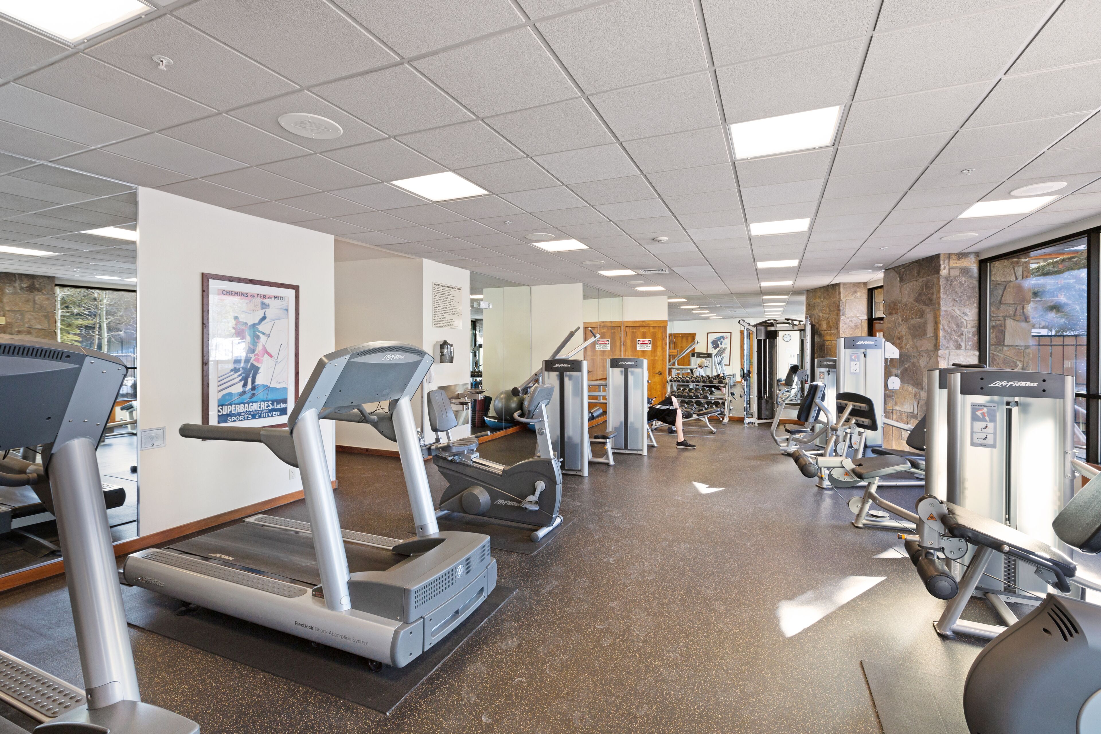 A gym with treadmills, elliptical machines, and weight equipment.