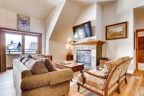 A living room with a fireplace, a television, and a sofa.