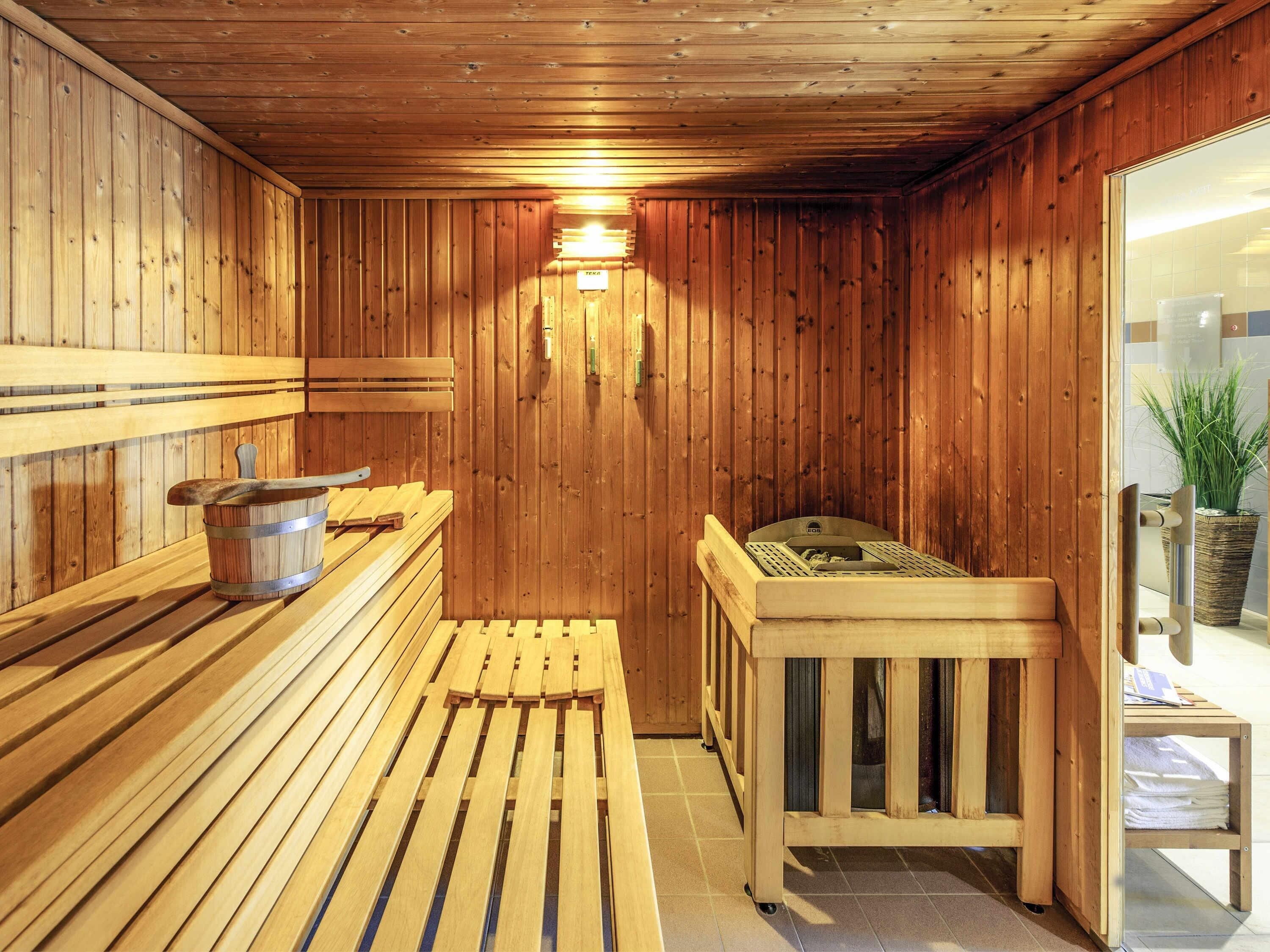A wooden sauna with benches, a bench seat, and a bench with a backrest.
